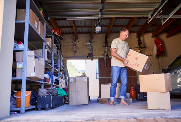 man moving boxes and organizing garage