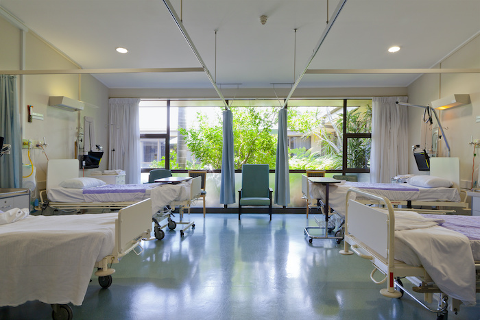 Beds lined up in a hospital ward