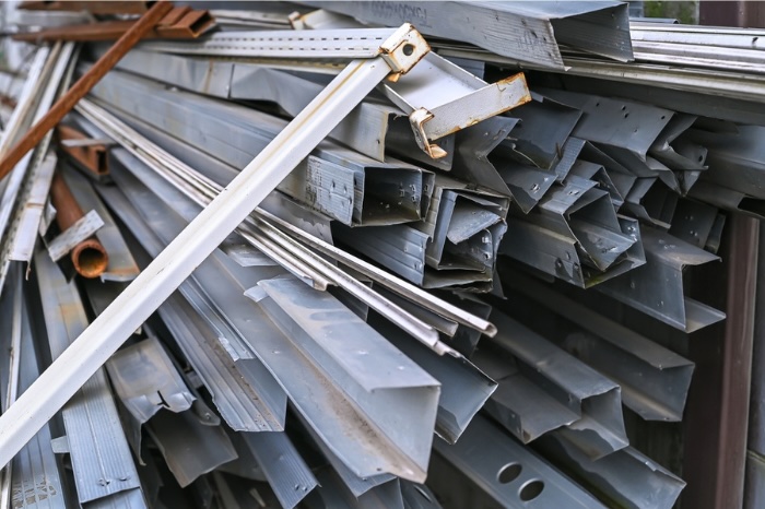 Silver scrap metal piled up outside at recycling center.