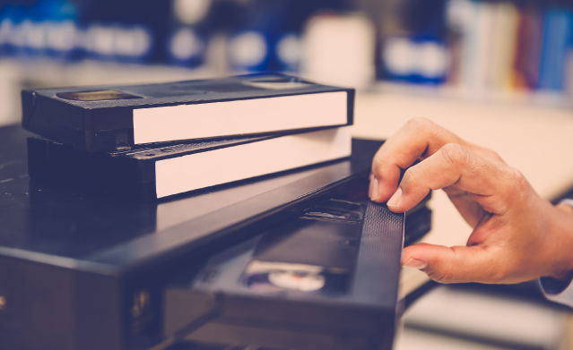 Person putting a VHS into a VCR