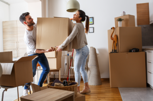 Couple surrounded by boxing packing up and moving