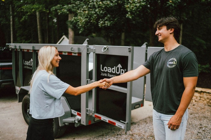 Junk removal professional shaking hands with a customer after a job well done