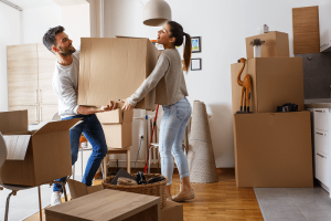 Man and woman carrying and moving boxes cleaning out their apartment