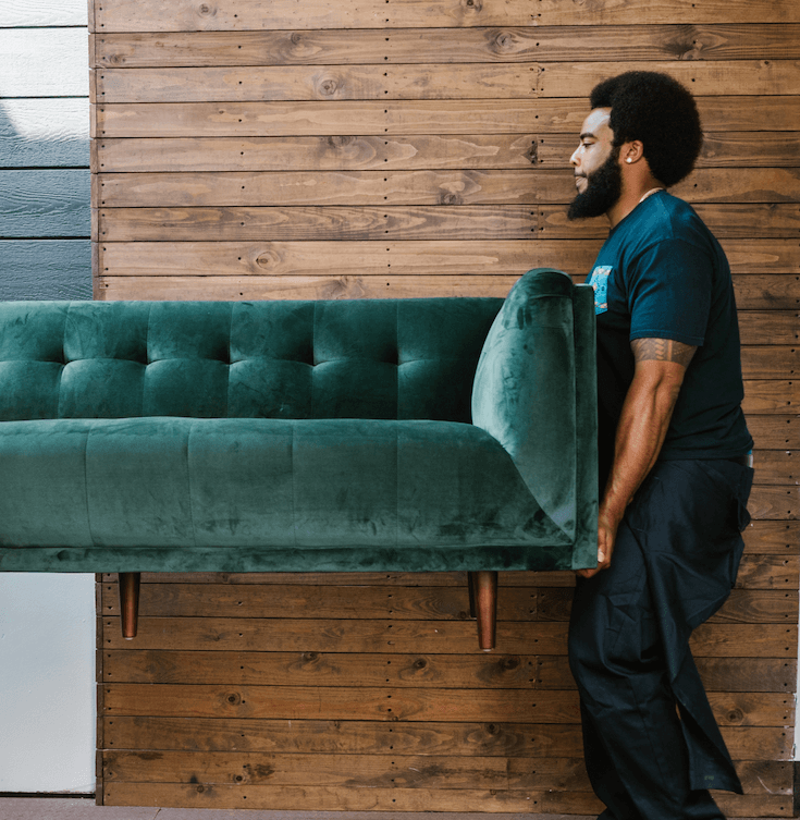 Professional donation pickup pro, carrying a couch to be taken to a donation center