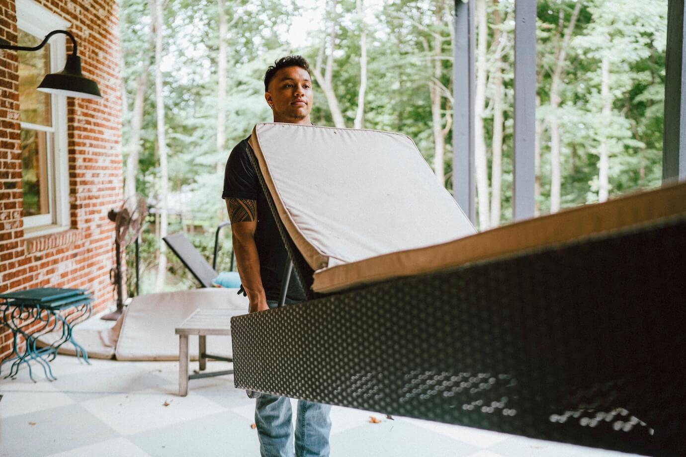 Professional hauler carrying an outdoor chair to be hauled away